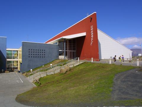Photo of Rimaskóli school building with grass in front and blue sky 